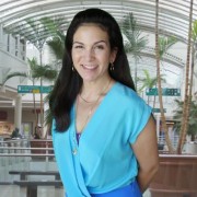 Woman with long dark hair standing in the atrium of a shopping mall